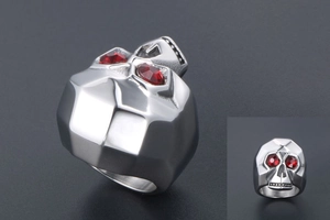 Macro detail of men's skull ring with polished silver finish and red crystal eye stones
