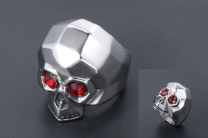 Detailed macro view of skull ring featuring red zircon eyes and geometric faceted design