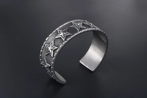 Macro shot of punk cuff bracelet featuring 3D star icons and mesh texture finish