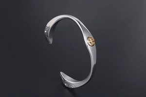 Macro detail of retro steel eagle cuff bracelet with vintage tribal carvings and gold emblem