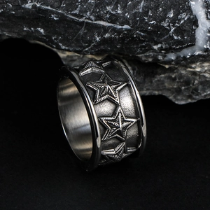 Vintage steel band ring featuring embossed star patterns and hammered metal texture