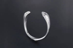 Detailed view of tribal style eagle head engraving on a vintage steel open cuff bracelet