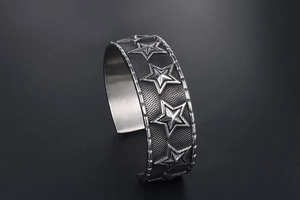 Detail of vintage silver cuff bracelet with 3D star motifs and mesh texture finish