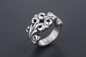 Macro view showing intricate baroque vine engraving on a wide titanium steel ring band