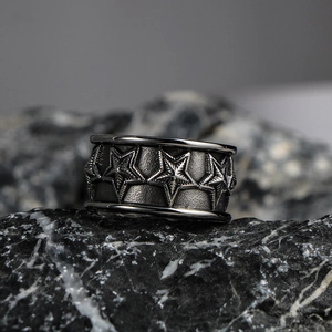 Wide titanium steel ring featuring carved five-star patterns and a vintage oxidized finish