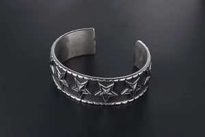 Detailed close-up of retro punk cuff bracelet with embossed stars and textured patterns