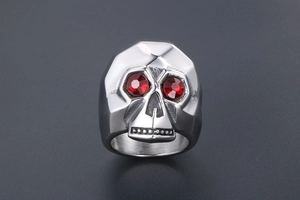 Macro shot of silver skull ring with red rhinestone eyes and geometric steel facets