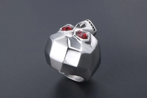 Macro detail of retro skull ring in stainless steel with striking red gemstone eyes