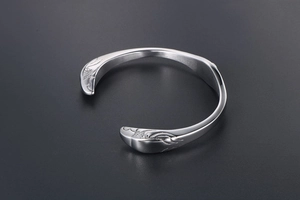 Detailed close-up of eagle wing engravings on vintage silver steel open cuff bracelet