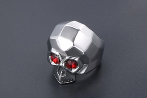 Macro shot of silver skull ring with red gemstone eyes and punk gothic metal details