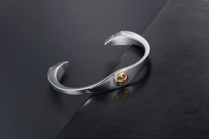 Detailed macro view of the eagle head engraving and golden emblem on the steel cuff