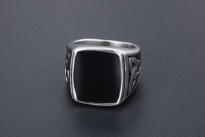Détail d'une bague chevalière carrée noire avec gravures de nœuds celtiques argent