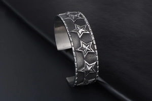 Detail of vintage star relief and mesh texture on retro silver punk cuff bracelet