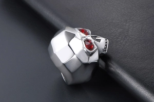 Macro detail of gothic skull ring in silver steel with faceted red crystal eyes
