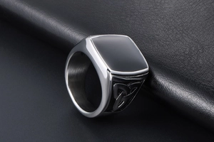 Détail de la bague en acier titane avec incrustation noire et motifs de nœuds celtiques