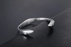 Detailed close-up of retro silver stainless steel bangle with eagle feather engraving