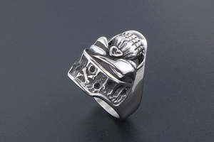 Detailed view of punk skull ring with hollow heart and crossbones in vintage steel