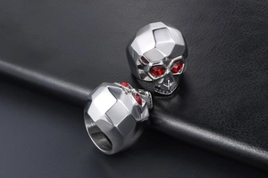 Detail of vintage skull rings with geometric cuts and red stone eyes on black leather