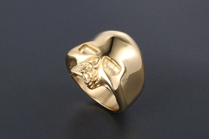 Macro detail of gothic skull ring in gold finish with realistic bone carving