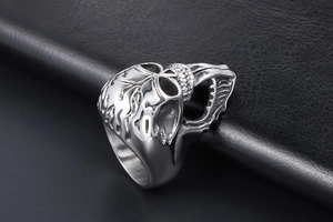 Detailed view of punk skull ring with long tongue and flame textures in titanium steel