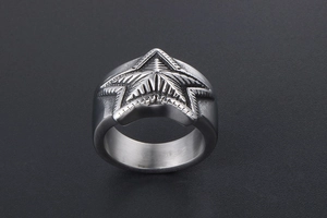 Macro view of wide stainless steel star ring with detailed radial textures and retro finish