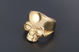 Detailed view of polished golden skull ring with intricate rock gothic carvings