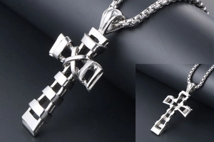 Macro detail of industrial style titanium steel cross pendant on robust silver box chain