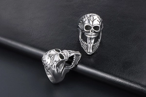 Detail shot of punk skull ring with long tongue design on black leather background