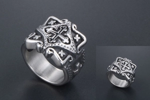 Macro detail of vintage stainless steel cross ring with gothic relief and matte finish