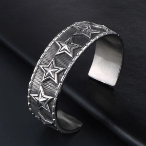 Vintage punk style wide open bangle with embossed stars and distressed silver finish