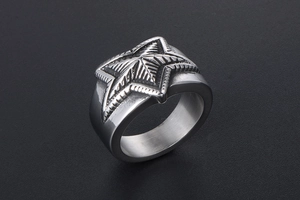 Macro detail of vintage stainless steel star ring with radial texture in silver
