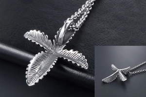 Macro detail of silver tropical palm leaf pendant with intricate vein textures on chain