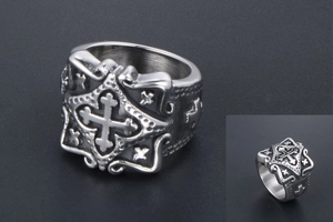 Macro detail of vintage stainless steel ring showing square cross relief and gothic texture