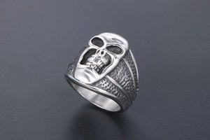 Détail d'une bague tête de mort en acier titane vintage avec finitions martelées