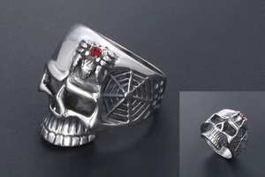 Detail of gothic skull ring with red rhinestone spider and engraved web pattern