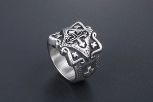 Macro view of vintage stainless steel ring with gothic cross relief and brushed finish