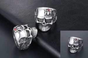 Detail view of retro skull ring featuring a red gemstone spider and cobweb textures