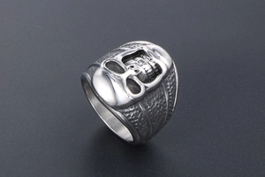 Détail d'une bague tête de mort punk avec finition polie et texture martelée sombre