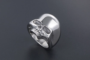 Macro shot of silver skull ring detail showing dark oxidation and metallic texture