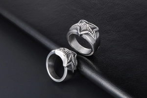 Macro shot of silver stainless steel star rings with grooved textures on black leather