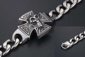 Macro detail of punk skull cross bracelet featuring heavy curb chain and lobster clasp