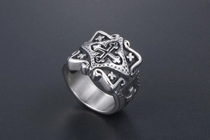 Close-up of vintage stainless steel cross ring with gothic floral engravings and silver finish