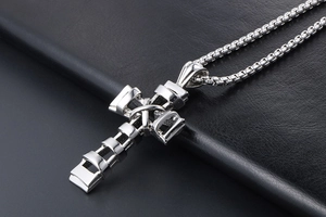 Polished silver titanium cross pendant with layered design on black leather background