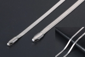 Macro detail of silver snake chain necklace showing dense flat metal link structure