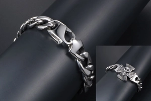 Close-up of punk style steel cuban chain bracelet with skull cross and lobster clasp
