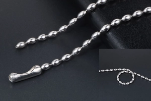 Detail of silver oval bead chain necklace in stainless steel on black leather background