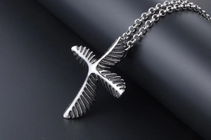 Macro detail of retro stainless steel leaf pendant showing metallic texture and ring chain