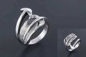 Macro shot of silver feather ring showing vintage texture and detailed metal engraving