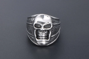 Détail de la bague tête de mort argentée vintage avec texture martelée et fini poli