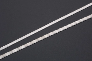 Macro shot of silver flat snake chain necklaces featuring detailed fish-scale metal texture
